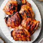 Serving platter piled with grilled maple Dijon chicken thighs.