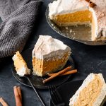 No bake pumpkin pie on a plate with a forkful taken out, with the rest of the pie in the background