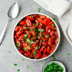 Bowl full of hot honey glazed carrots and garnished with parsley