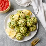 Spinach and Feta Chicken Meatballs piled on a plate and garnished with lemon wedges