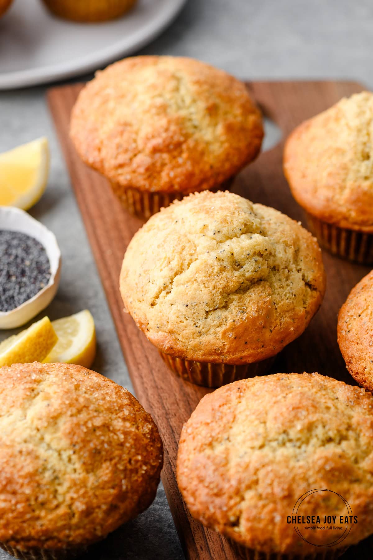 Row of lemon poppyseed muffins on a wooden cutting board