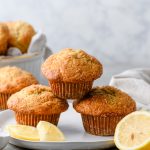 Stack of gluten free lemon poppy seed muffins, with slices of lemon around them