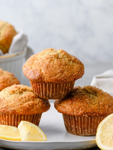Stack of gluten free lemon poppy seed muffins, with slices of lemon around them