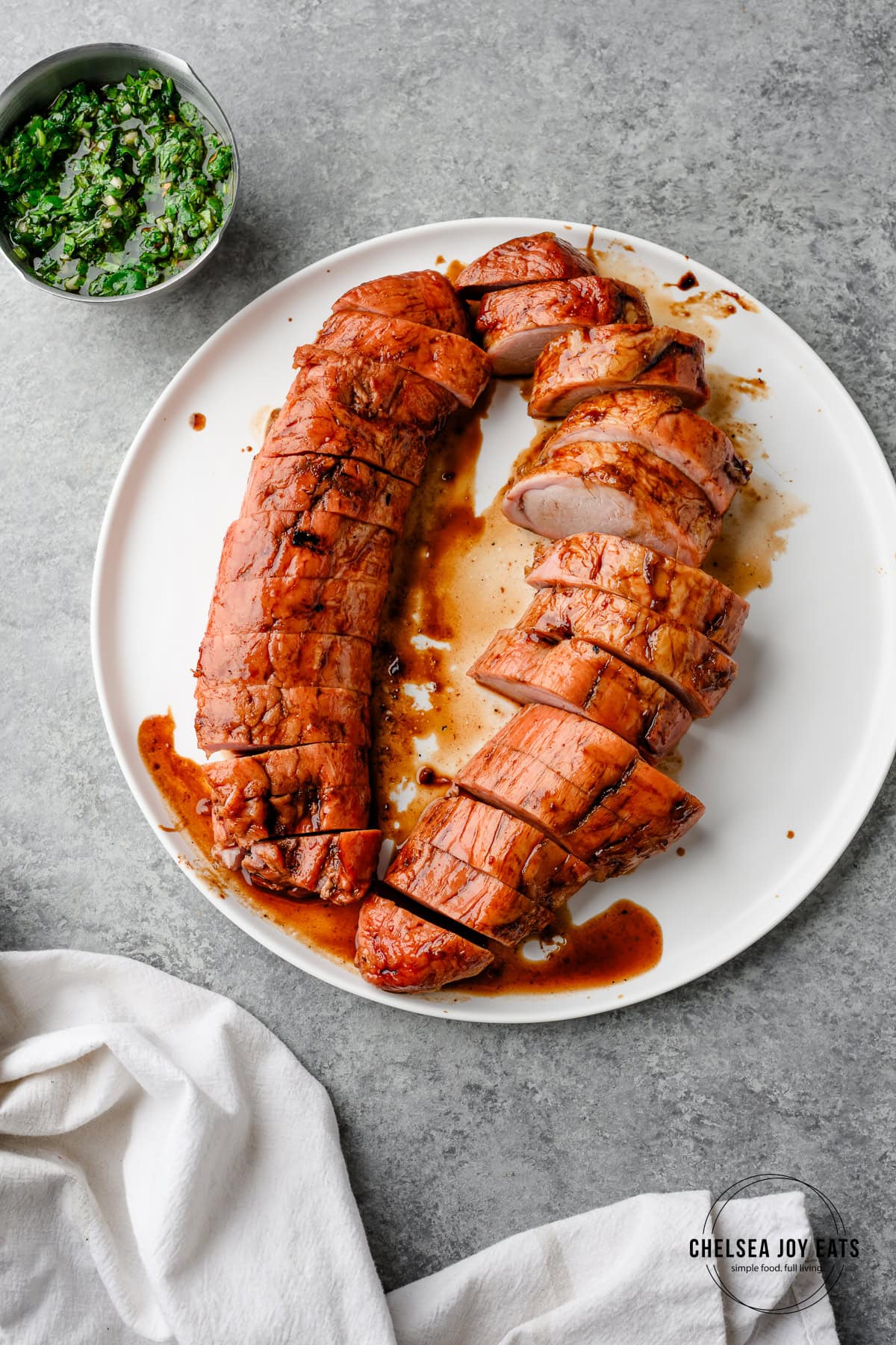 Balsamic glazed pork tenderloins on a plate, one sliced into coins
