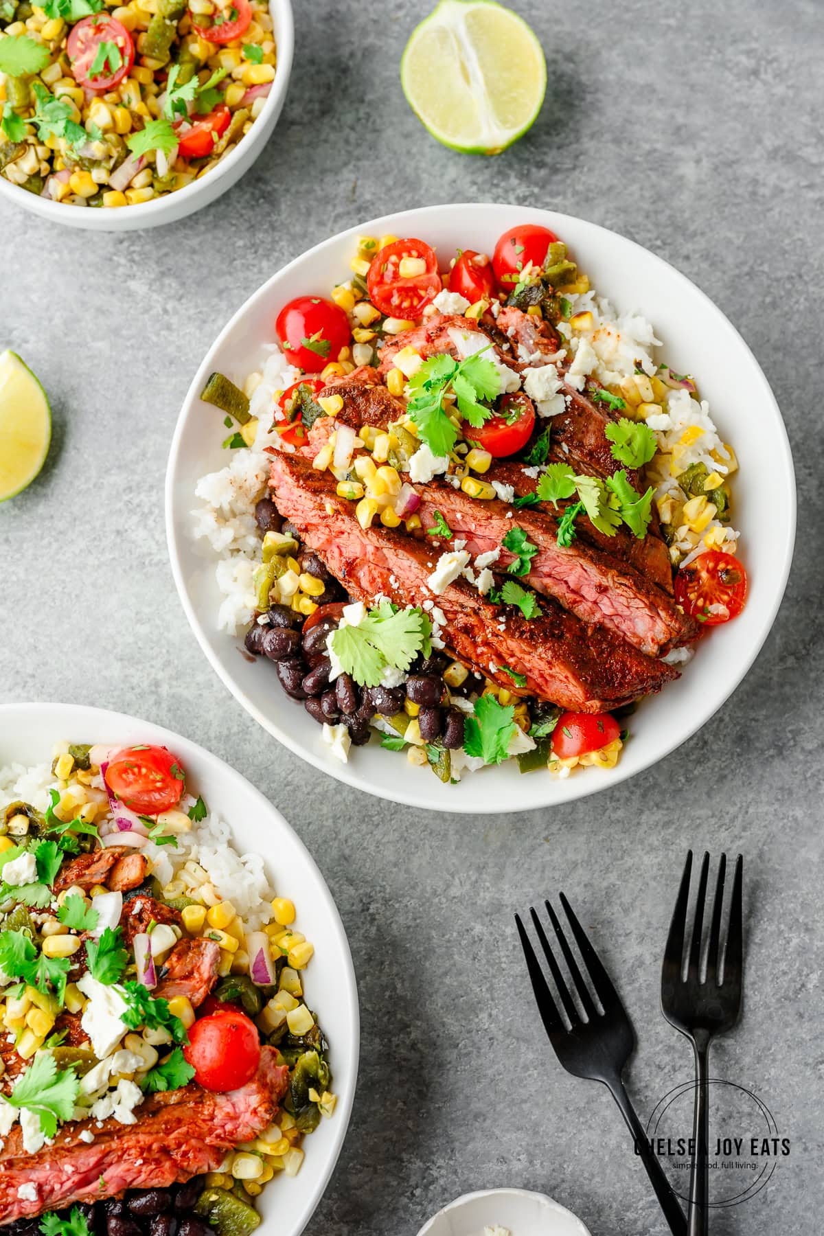 Rice bowls topped with ancho skirt steak, black beans, and poblano corn salsa, topped with feta cheese