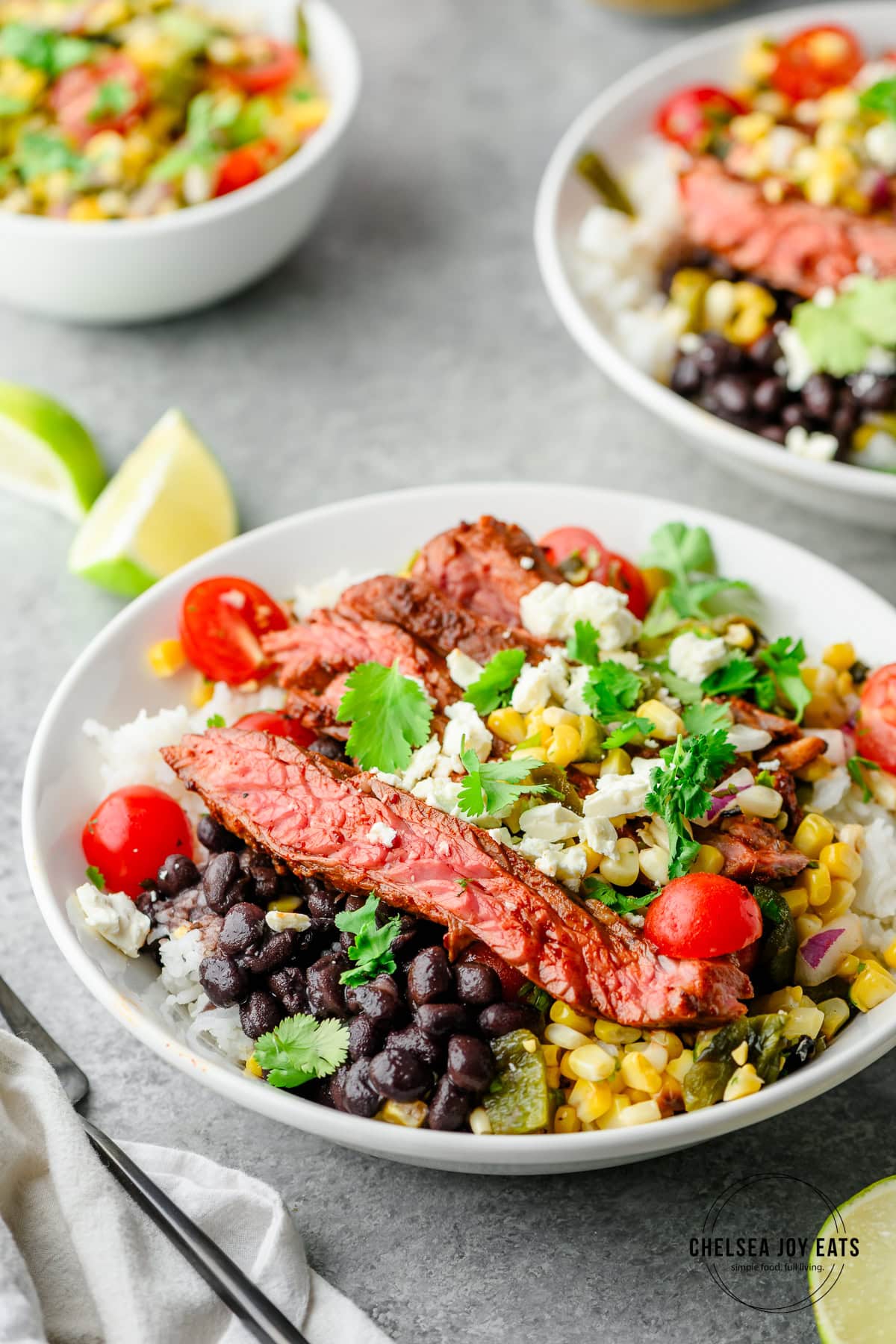 Closeup of an ancho skirt steak bowl served with rice, black beans, and poblano corn salsa