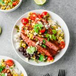 Overhead view of a rice bowl topped with poblano corn salsa, black beans, and ancho skirt steak