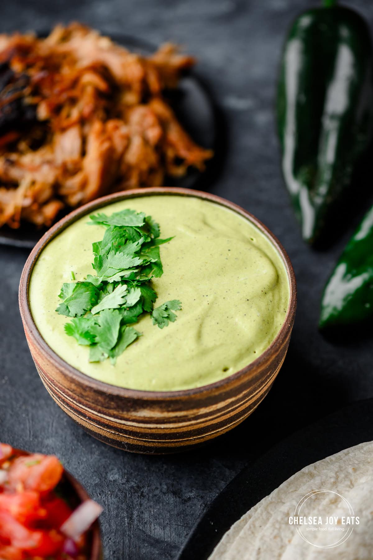 Closeup of a bowl filled with vibrant green poblano sauce made with Greek yogurt