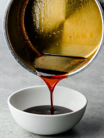Teriyaki sauce being poured from a saucepan into a bowl