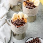 Chunky monkey chia pudding made with peanut butter powder and banana, topped with peanut butter, sliced banana, and chopped dark chocolate