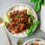Overhead view of Thai-Style Basil Ground Turkey served over rice and garnished with basil and a wedge of lime
