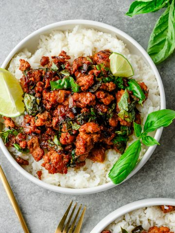 Overhead view of Thai-Style Basil Ground Turkey served over rice and garnished with basil and a wedge of lime