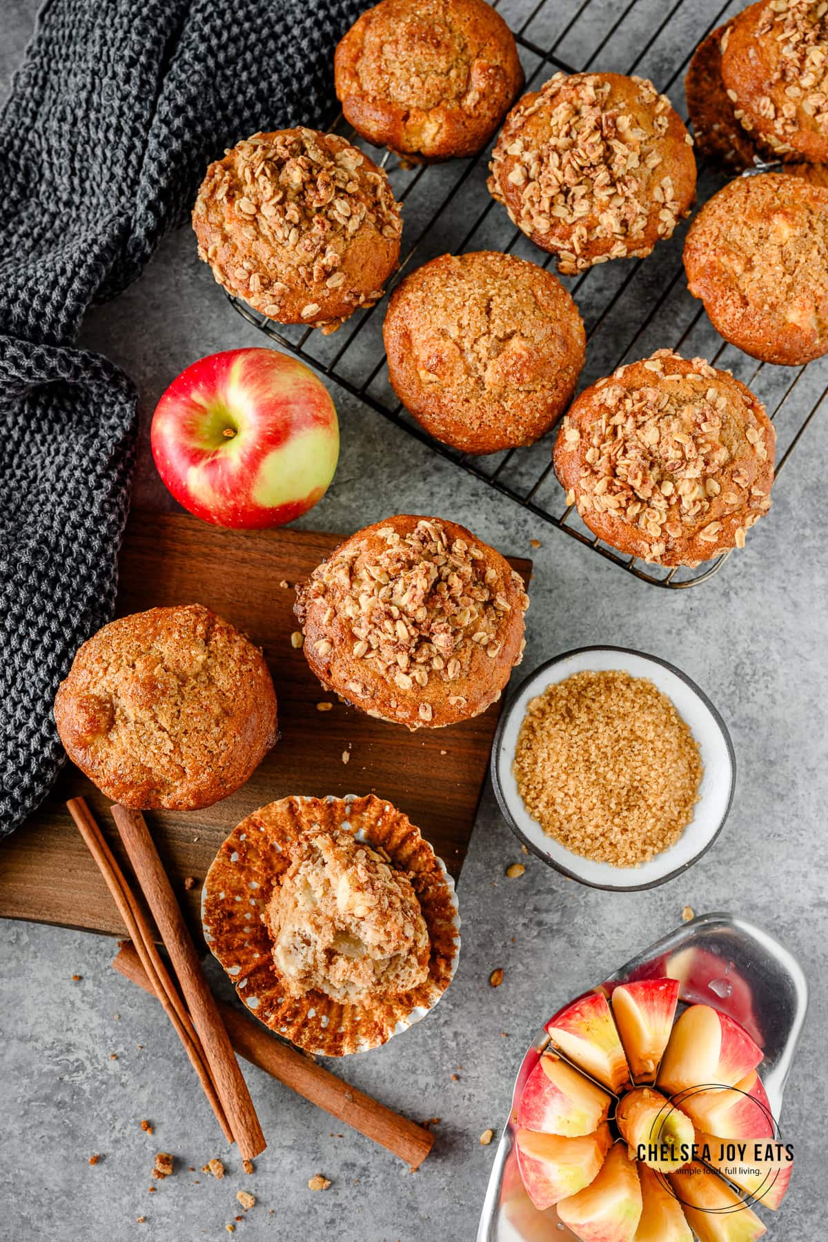 Overhead view of gluten free apple muffins, one half-eaten on a cutting board