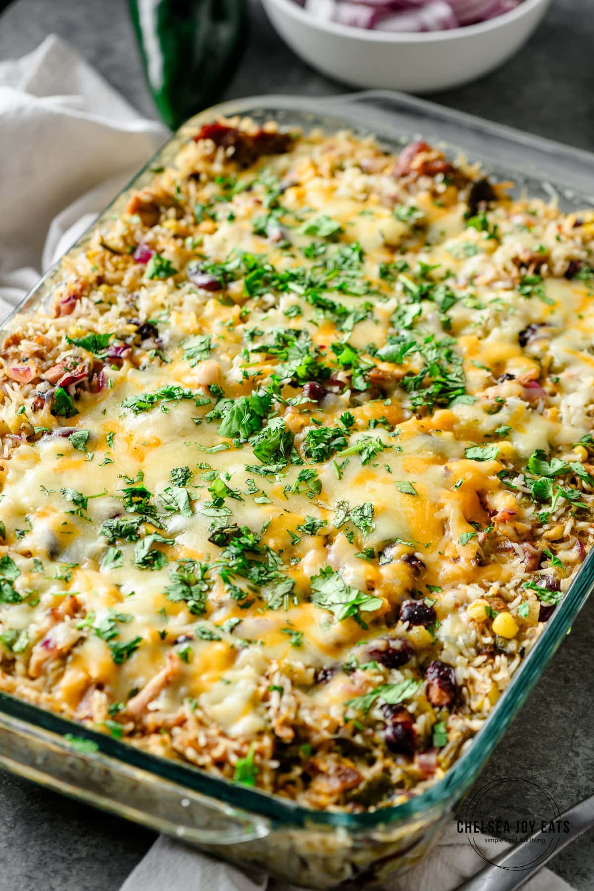 Closeup of a leftover pulled pork casserole with rice, cheese, beans, and corn, topped with cheese and cilantro
