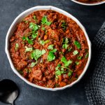 Overhead view of a bowl filled with flank steak chili topped with fresh minced cilantro
