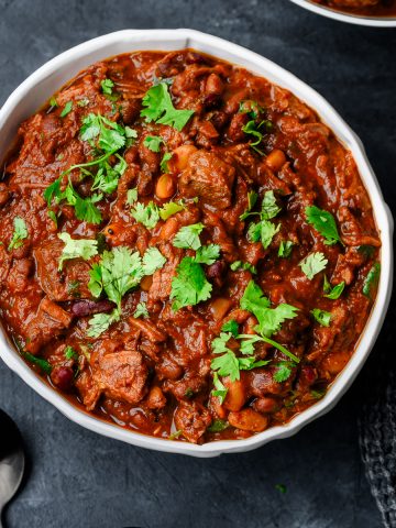 Overhead view of a bowl filled with flank steak chili topped with fresh minced cilantro