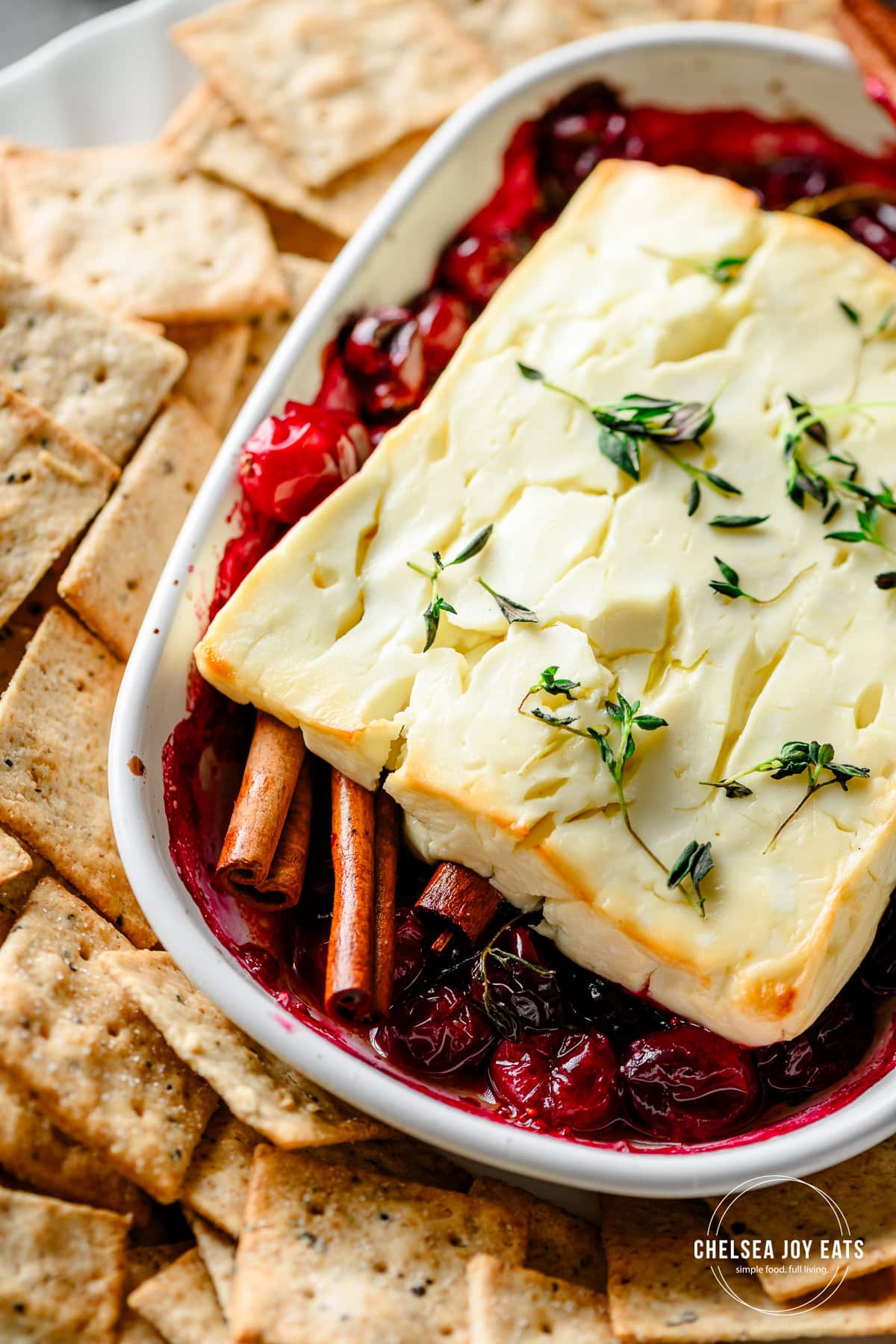Closeup of baked feta cheese served over cranberries and cinnamon
