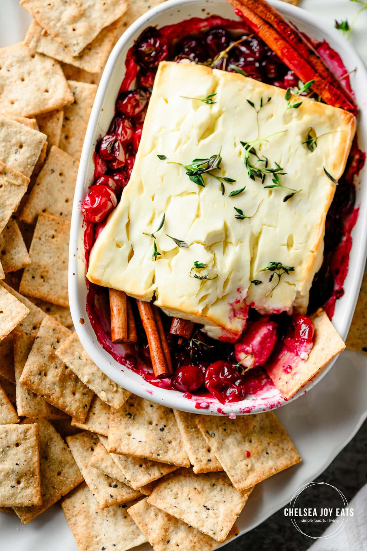 Closeup overhead view of cranberry baked feta cheese served with gluten free crackers