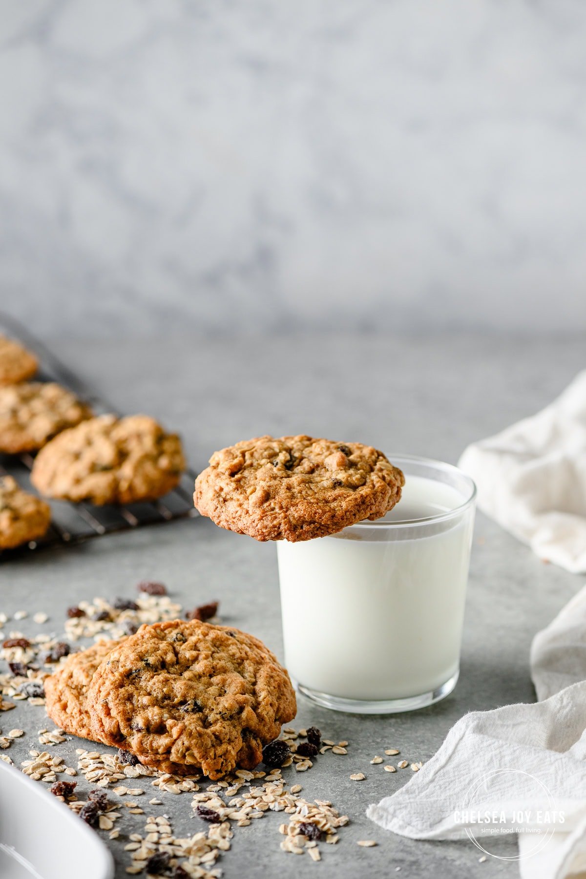 Gluten free oatmeal raisin cookie balancing on a glass of milk