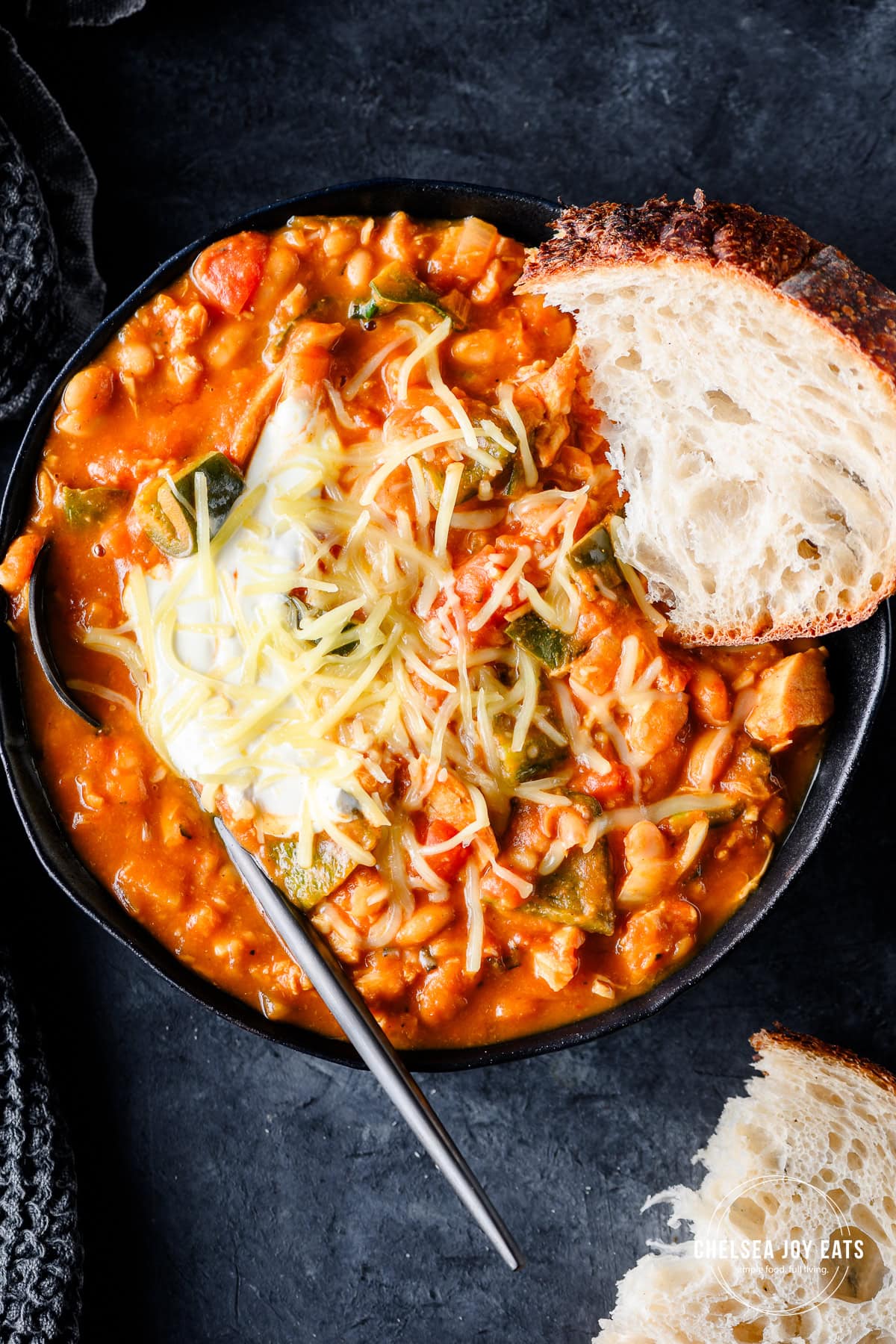 Closeup of turkey and pumpkin chili served with sour cream and sourdough bread