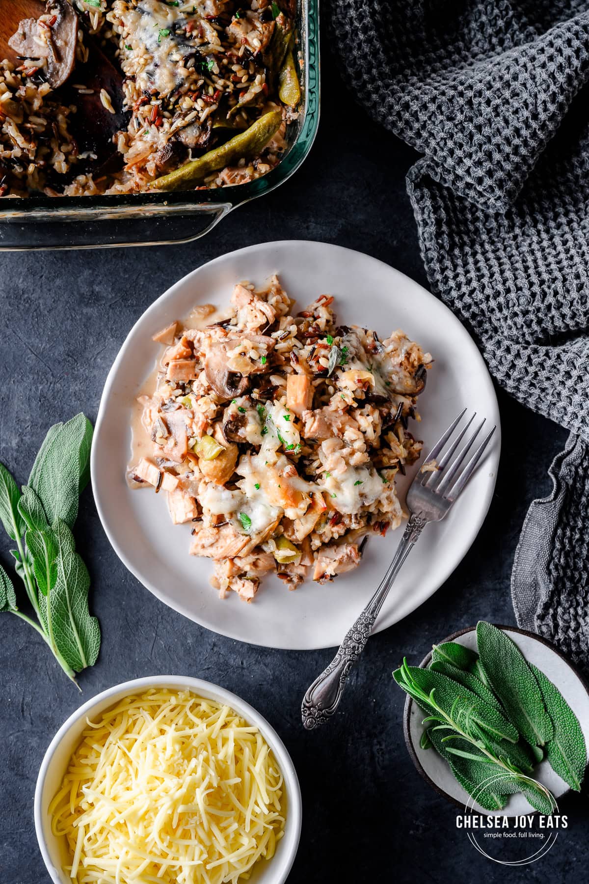 Overhead view of a serving of gluten free turkey and wild rice casserole, with fresh herbs as garnish