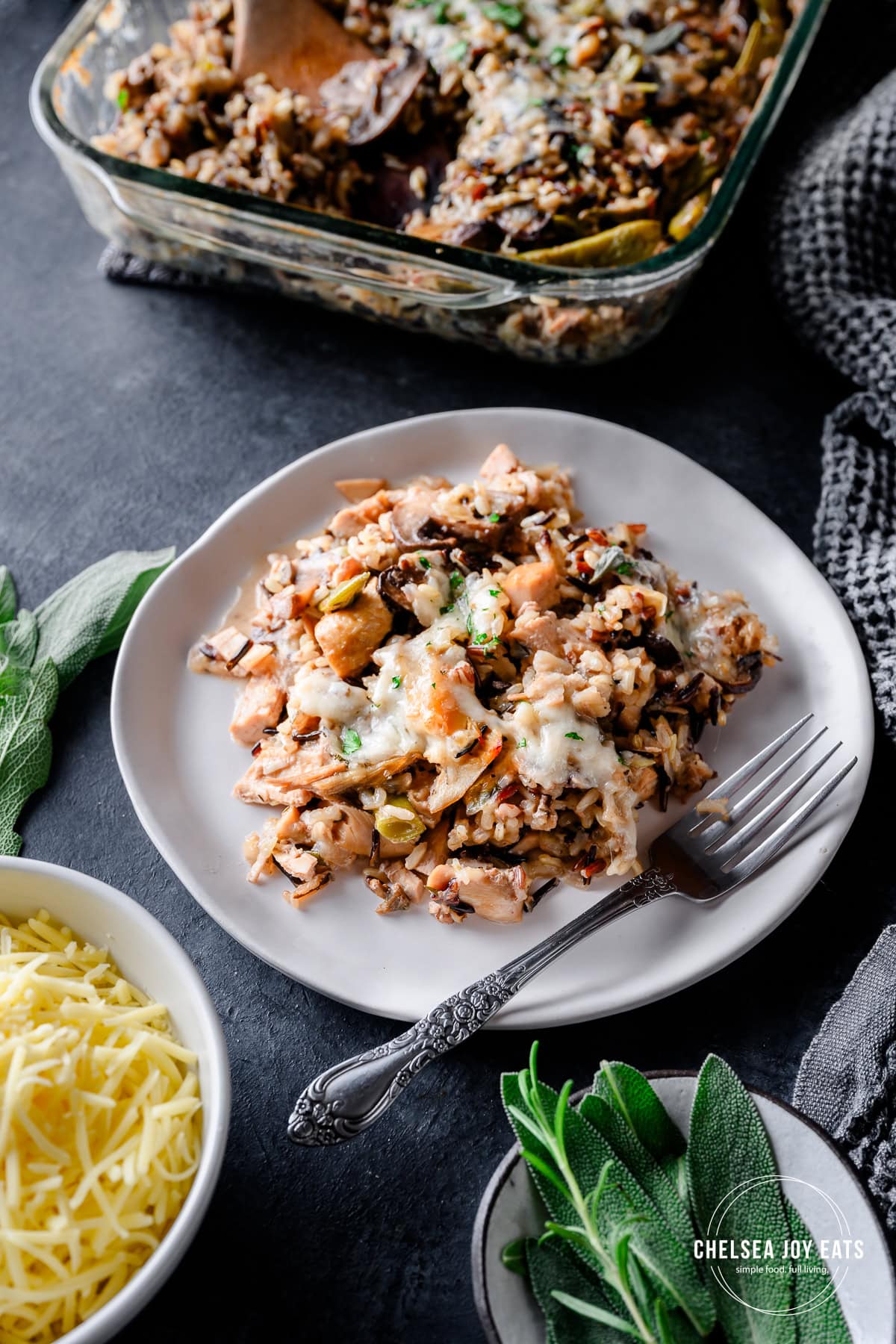 Serving of wild rice and turkey casserole, with the casserole dish in the background