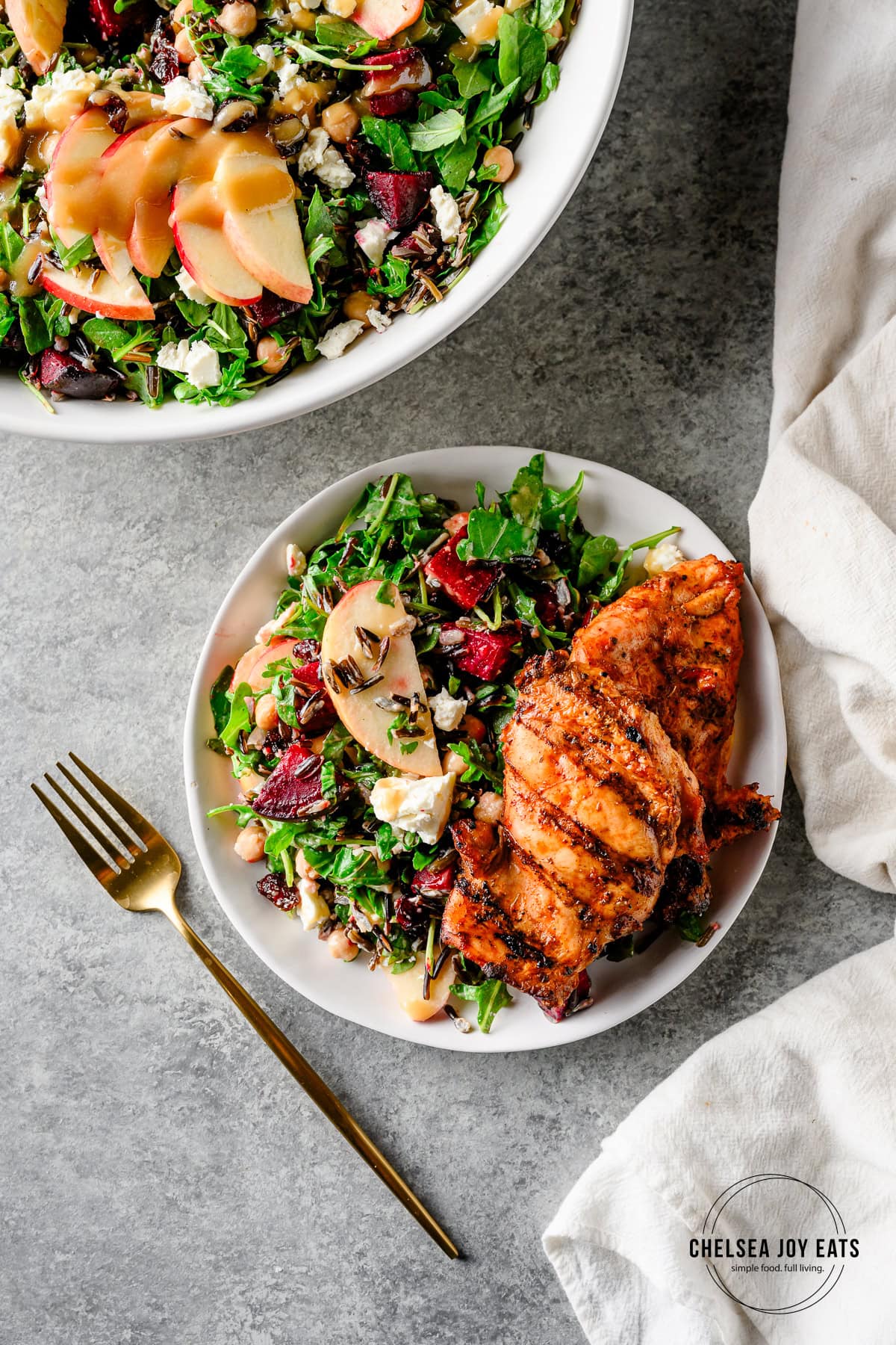 Serving of wild rice and arugula salad with grilled chicken thighs