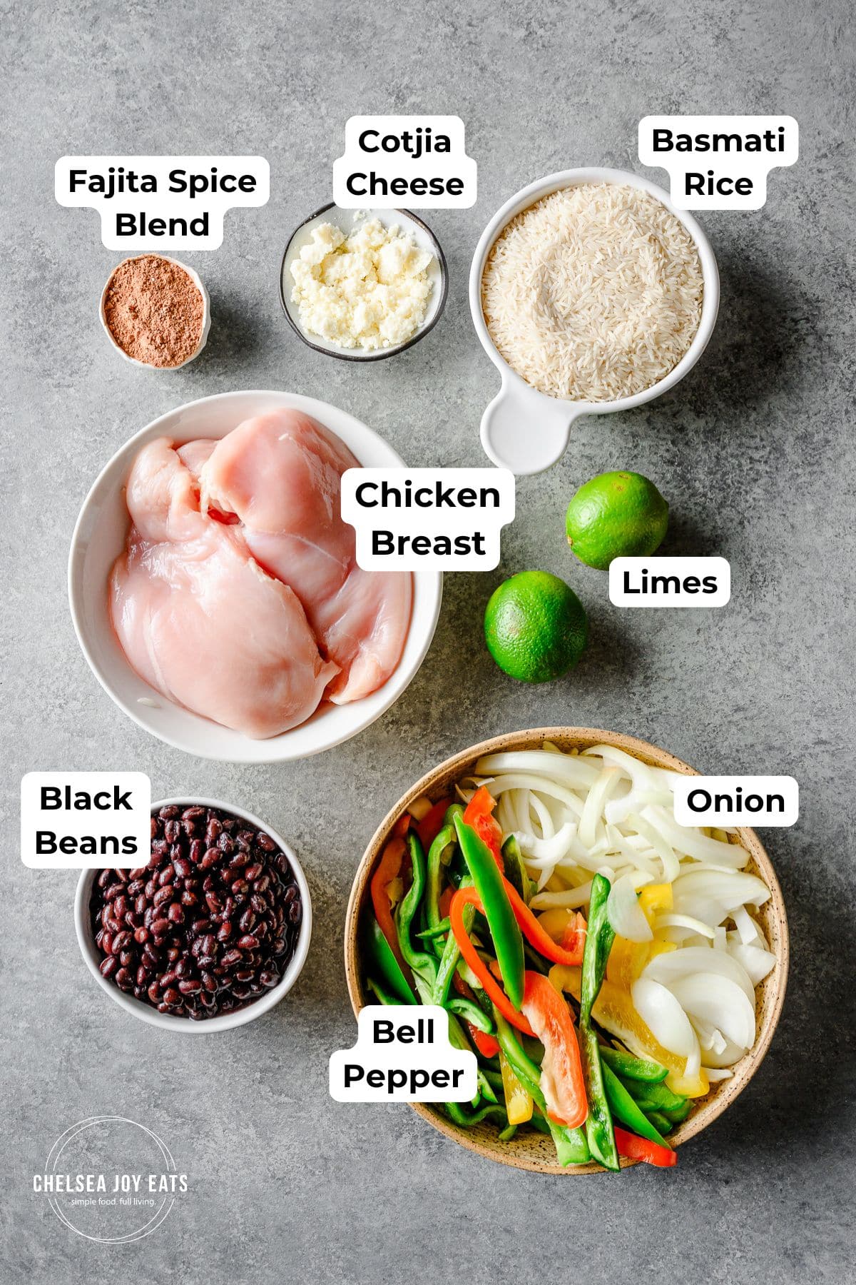 Ingredients for fajita chicken bowls with bell peppers, onions, black beans, and rice, with text labels for each ingredient