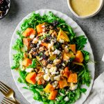 Platter with an arugula and winter squash salad served with vanilla orange vinaigrette