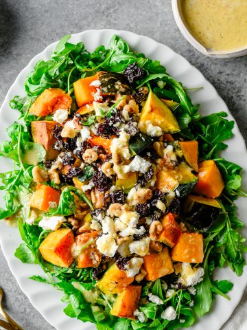 Platter with an arugula and winter squash salad served with vanilla orange vinaigrette