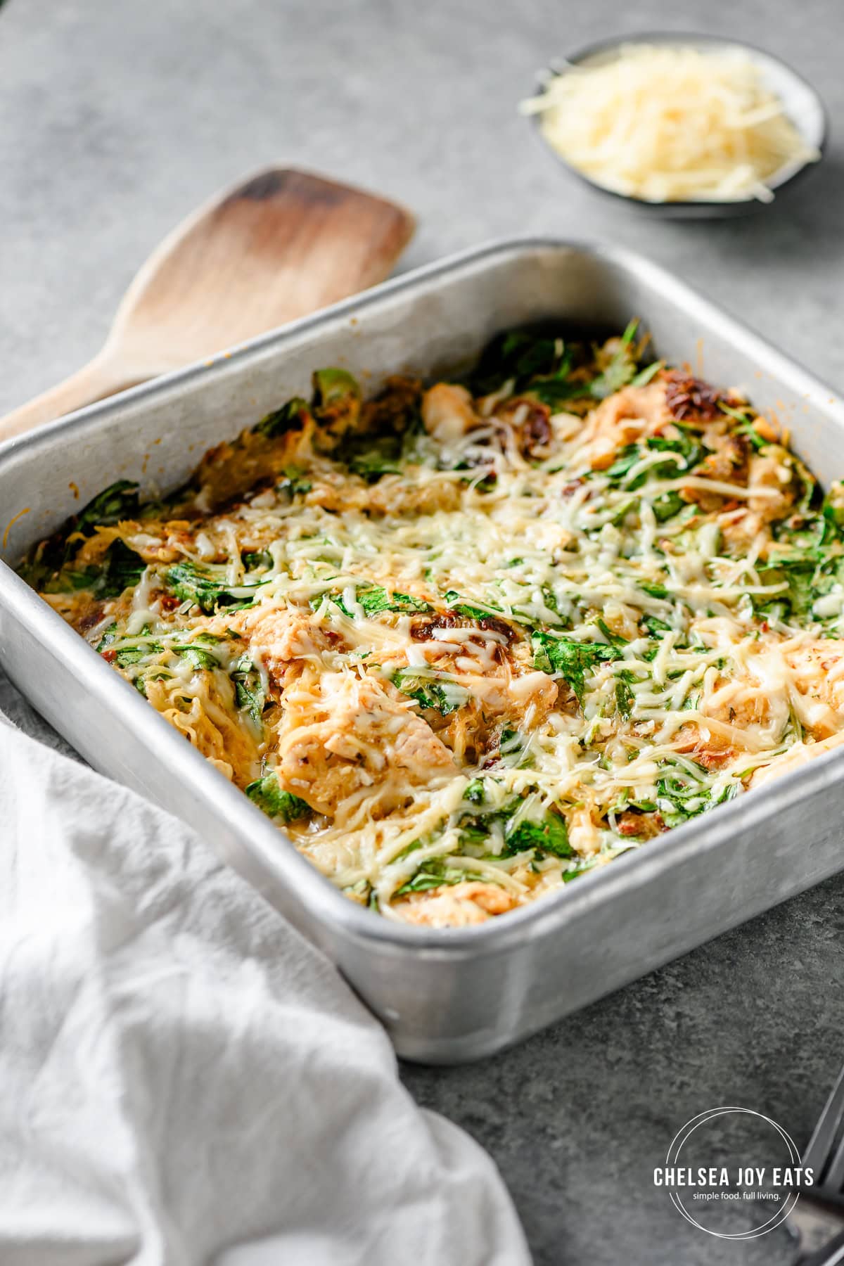 Closeup of a finished spaghetti squash and feta casserole topped with parmesan cheese