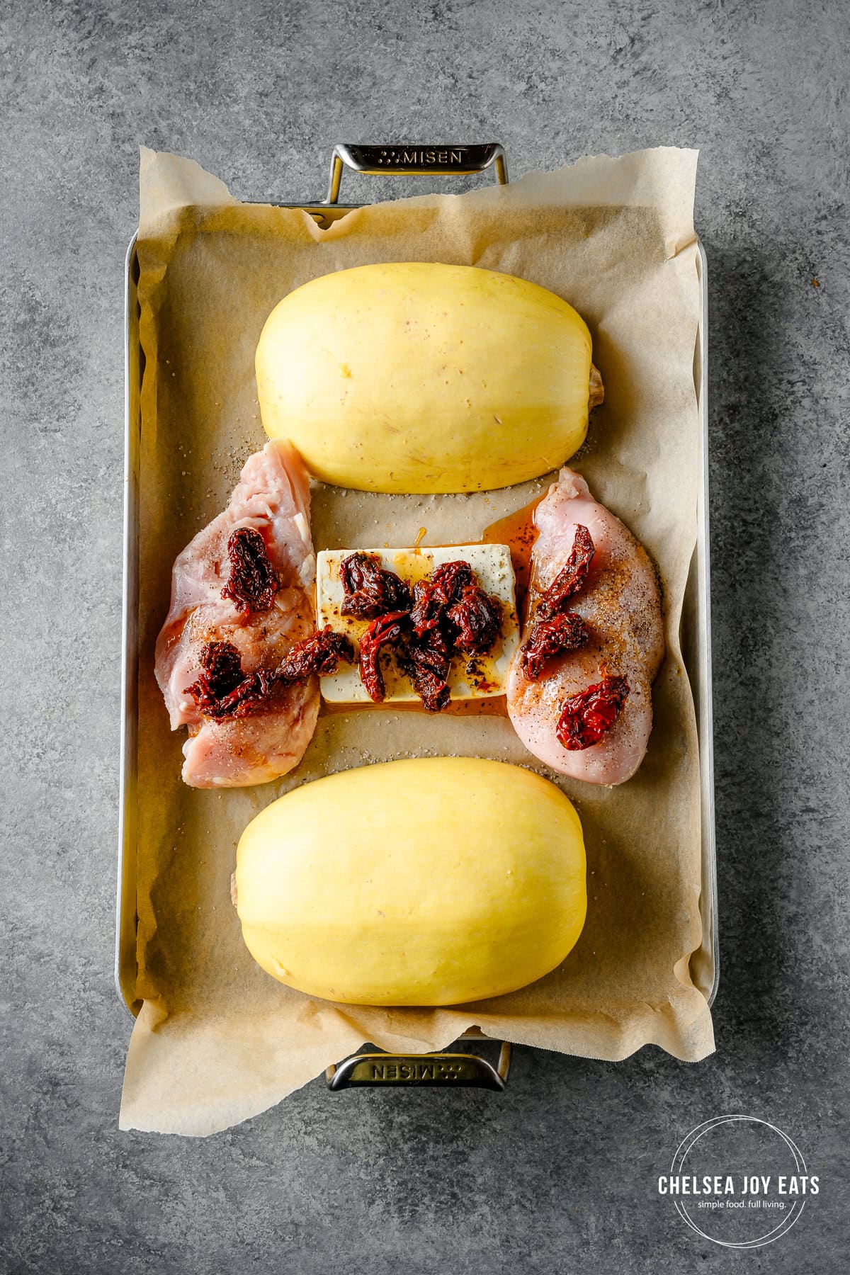 Spaghetti squash, chicken, feta cheese, and sun-dried tomatoes on a baking sheet