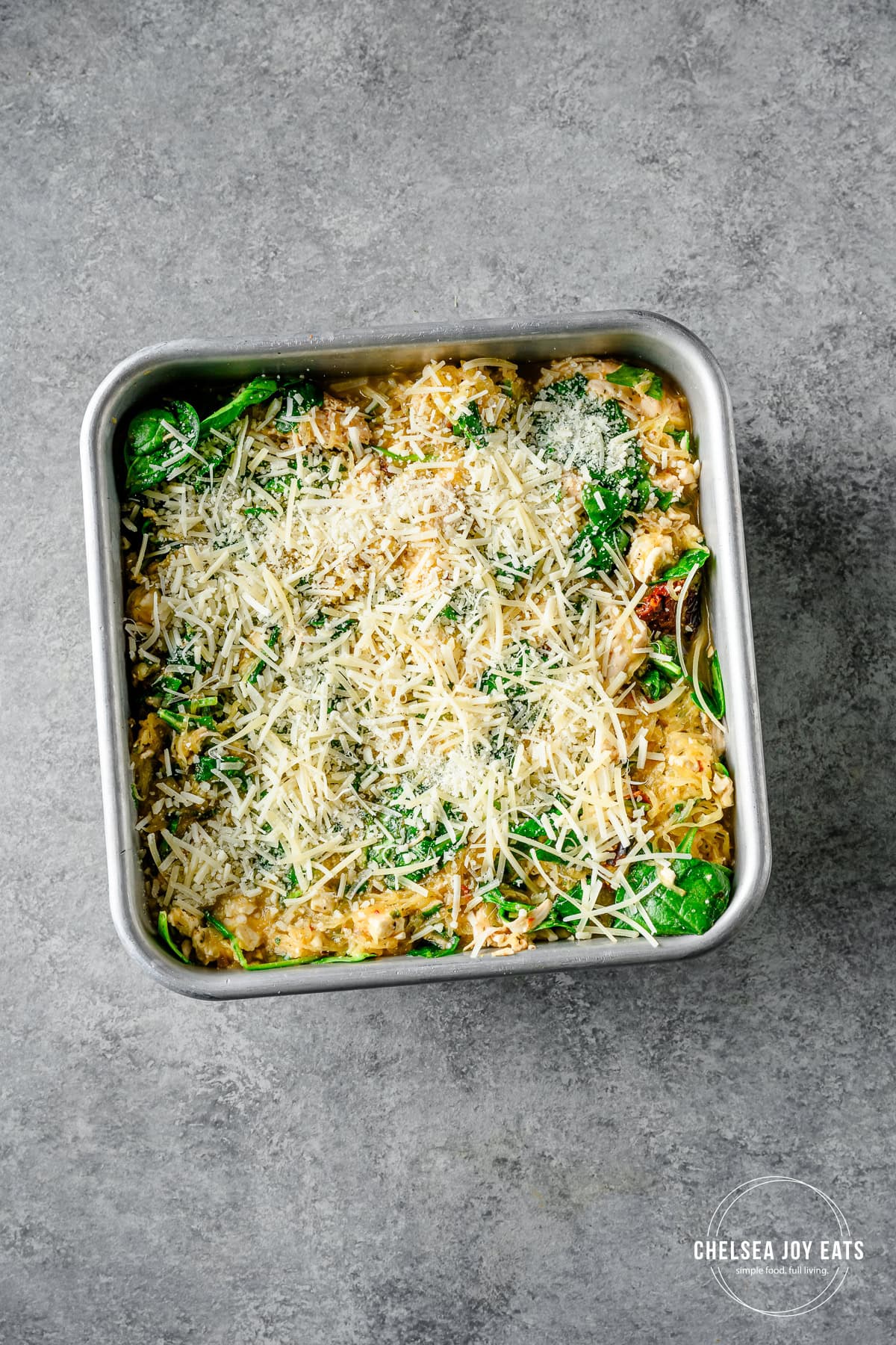 Overhead view of uncooked spaghetti squash casserole topped with parmesan cheese