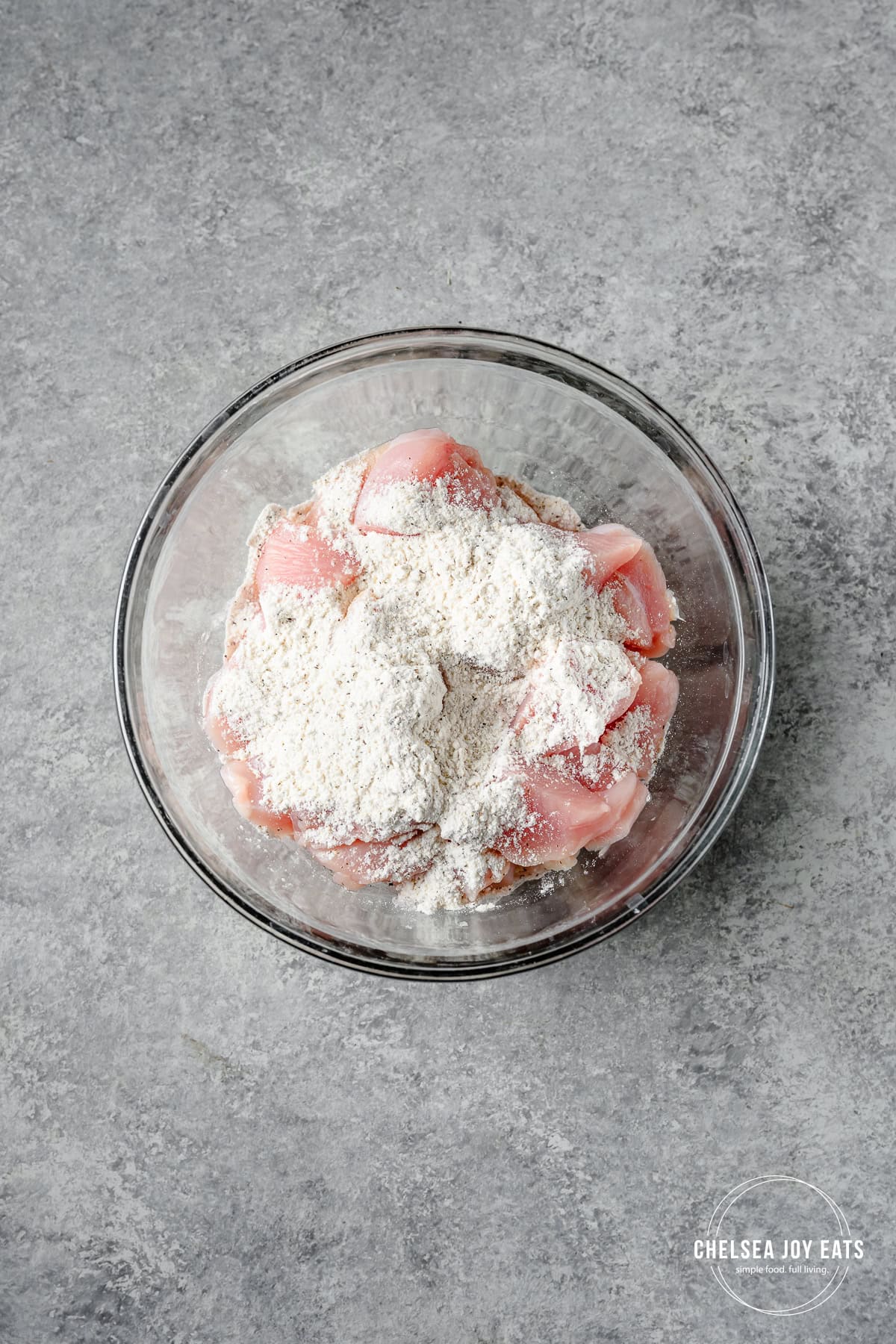 Chicken pieces in a bowl with flour and spices