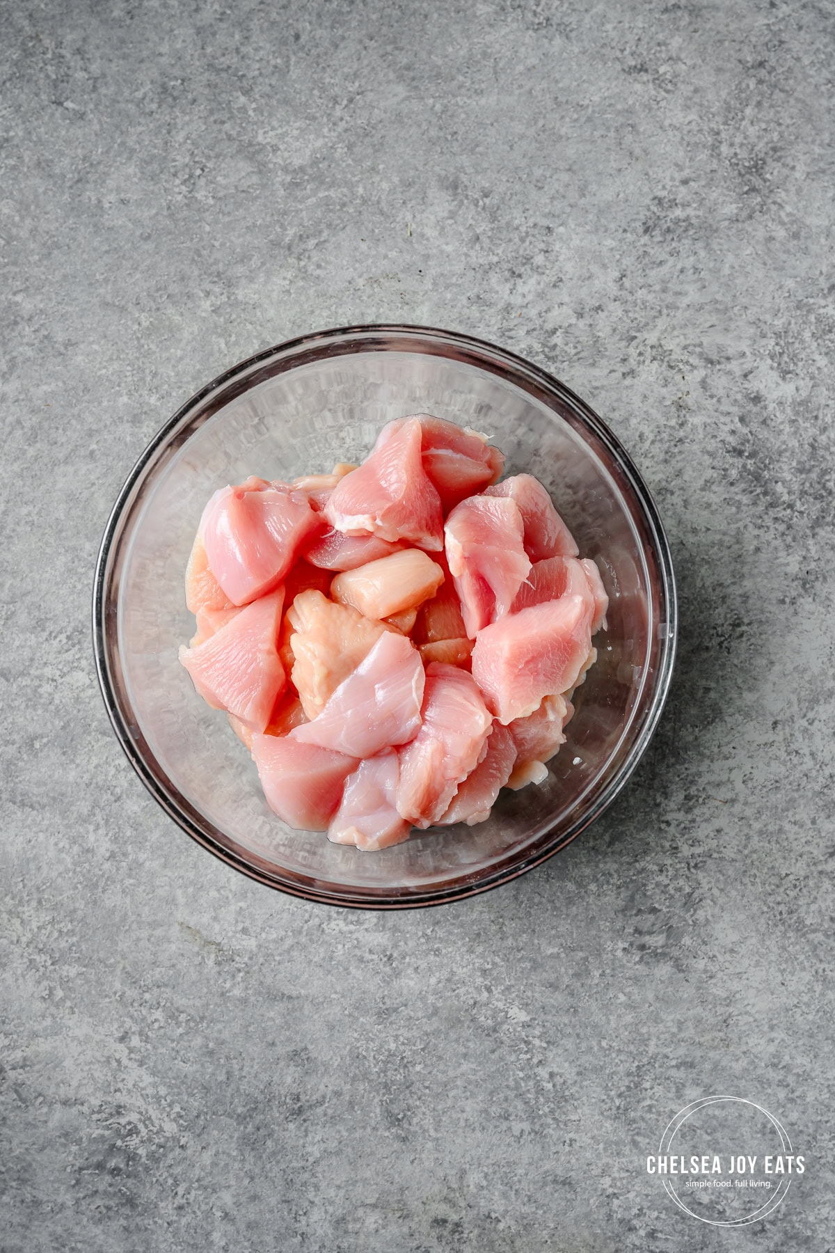 Raw chicken breast cut into 1 ½ inch to 2 inch pieces in a bowl.