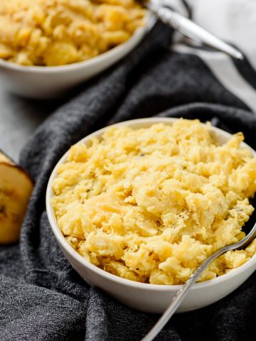 Closeup of a bowl of gluten free mashed plantains, with another bowl in the background