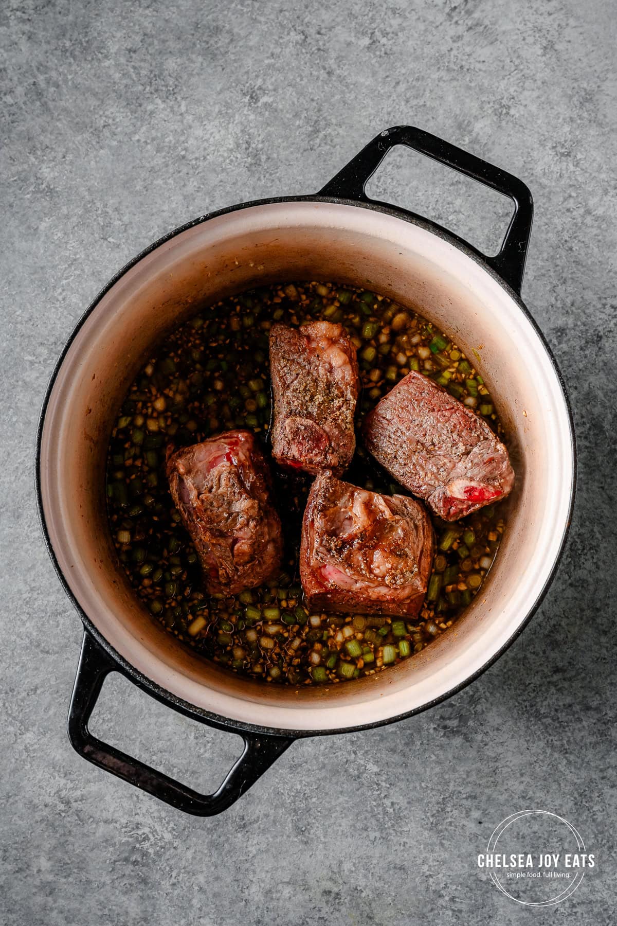 Beef short ribs, ginger, scallions, and broth in a Dutch oven.
