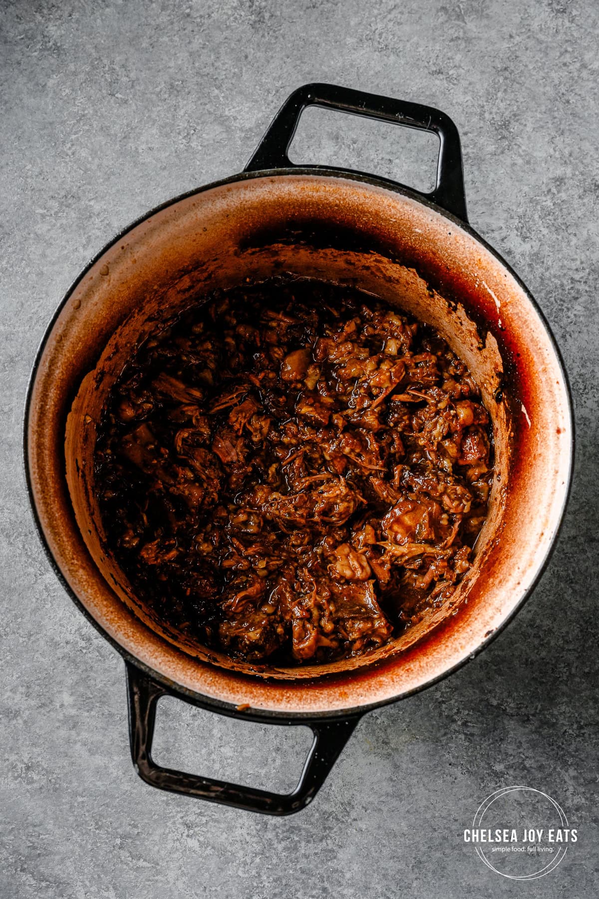 Shredded beef short ribs stirred with a ginger scallion sauce in a Dutch oven.