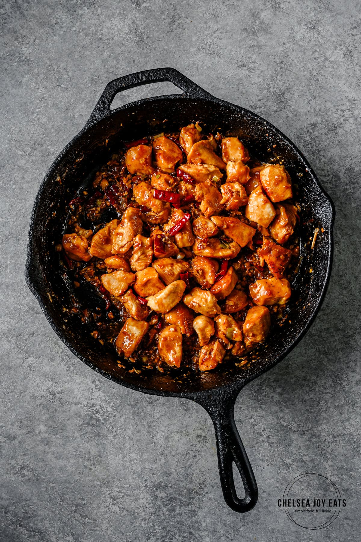 Finished gluten free kung pao chicken pieces and sauce in a cast iron skillet.