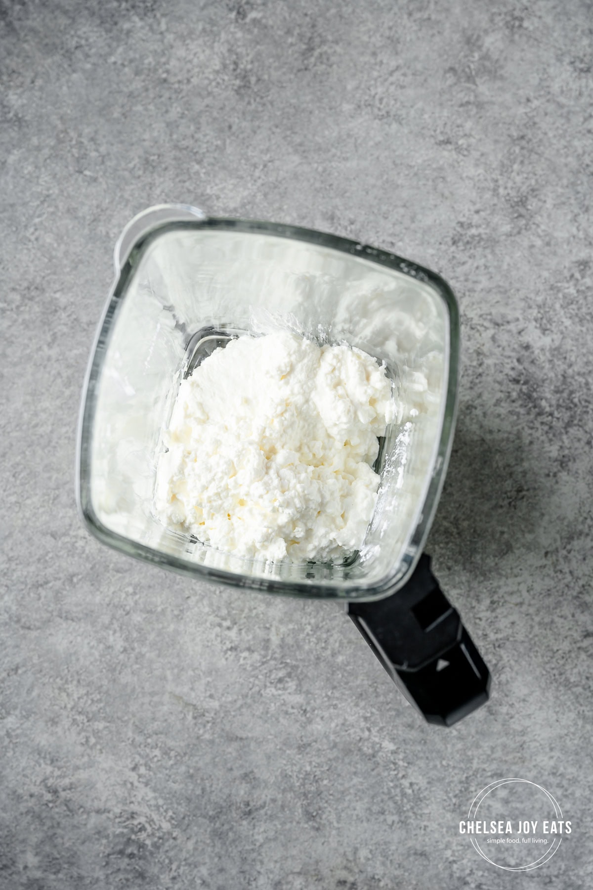 Blender pitcher with cottage cheese inside.