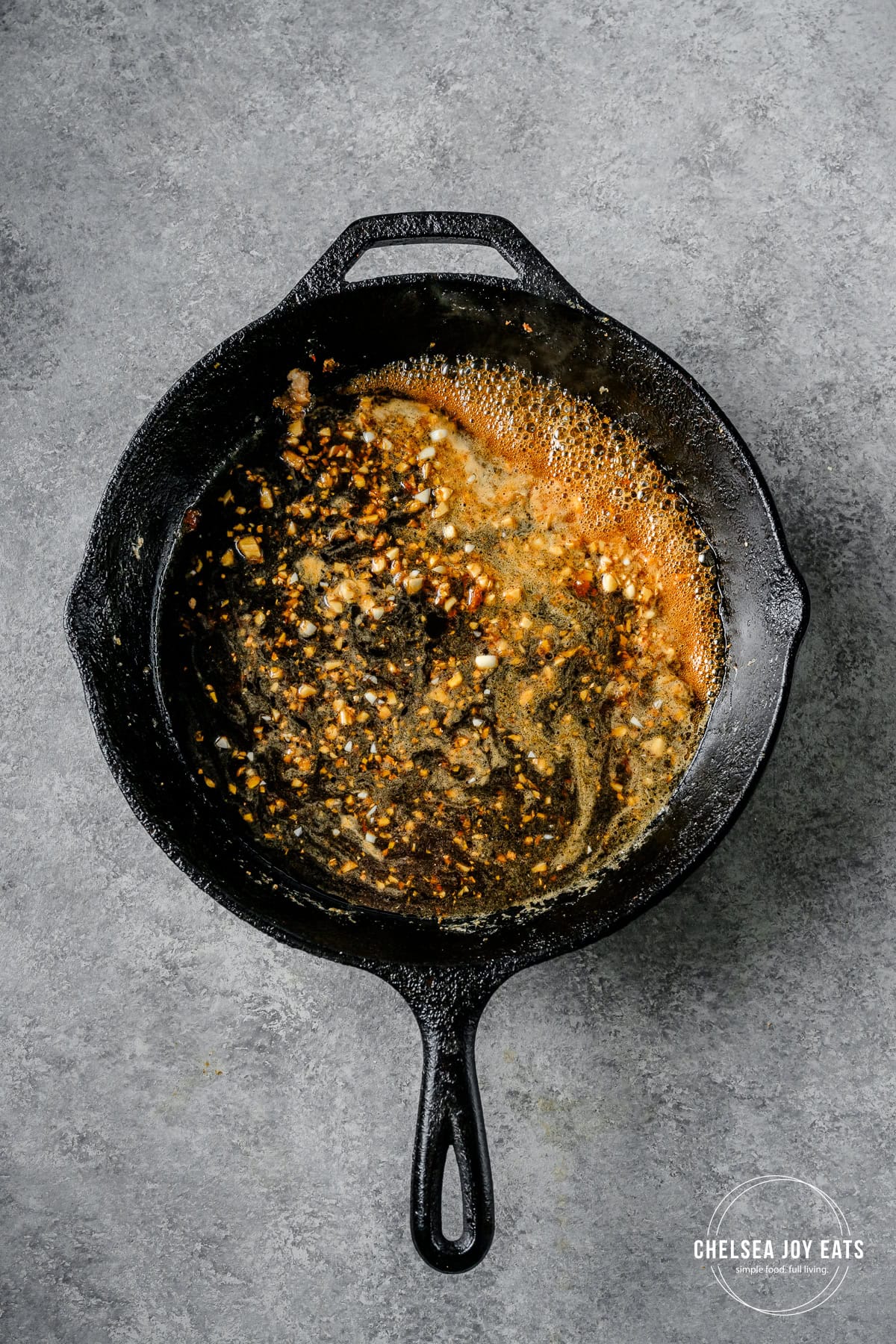 Honey sesame sauce reducing in a hot cast iron skillet.