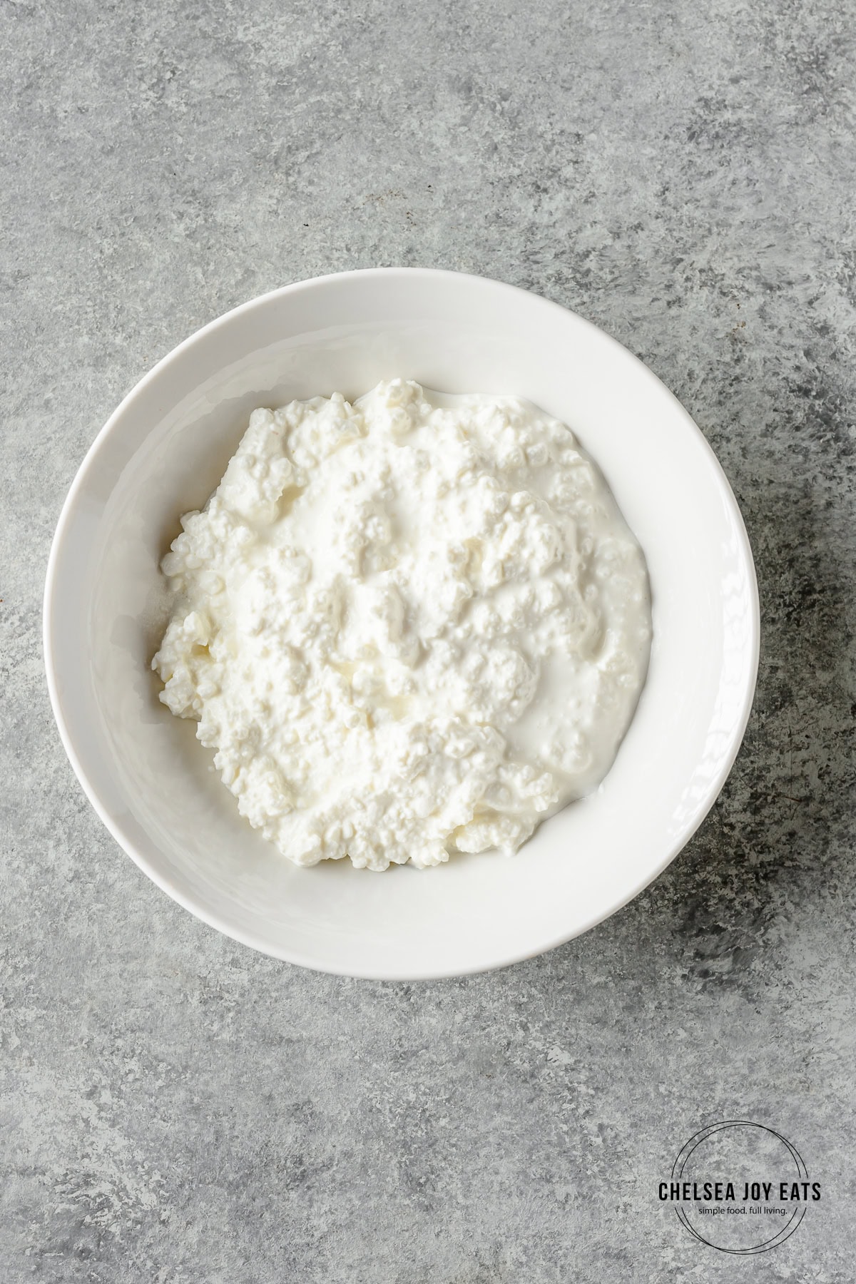 Plain cottage cheese in a white ceramic bowl.