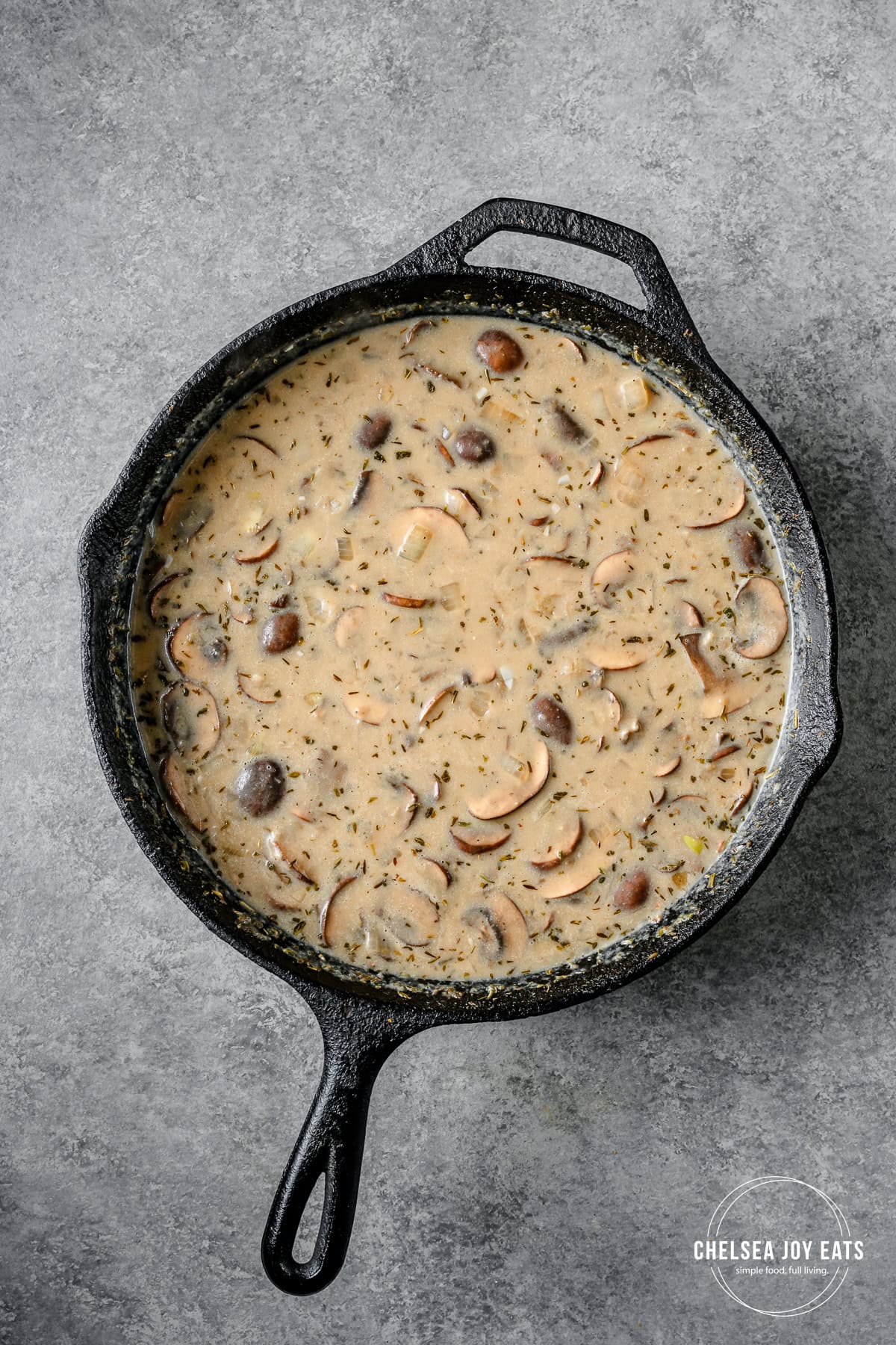 Mushroom gravy for gluten free tater tot casserole thickening in a cast iron skillet.