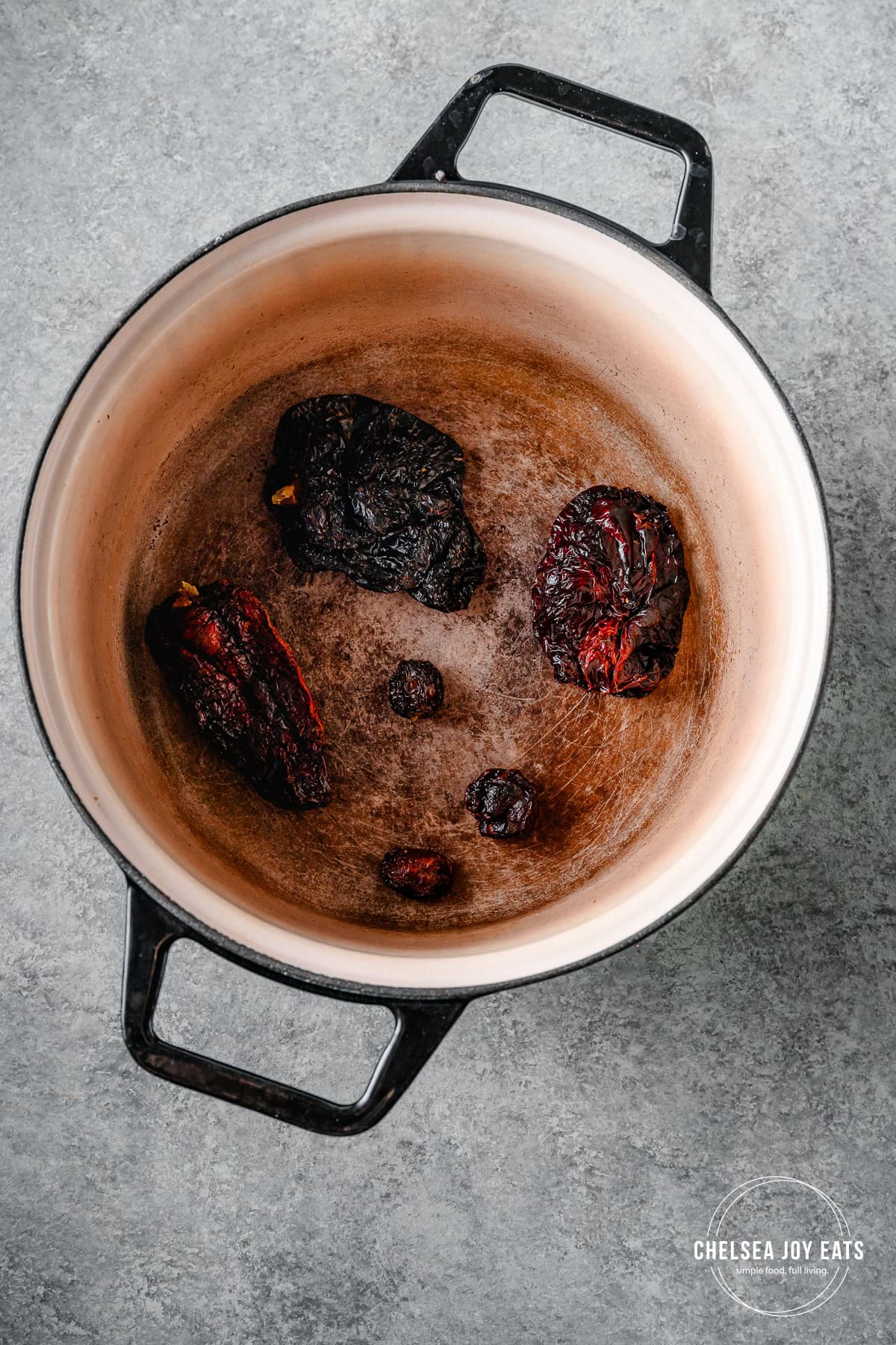 Dried ancho and chipotle chiles searing in a Dutch oven.