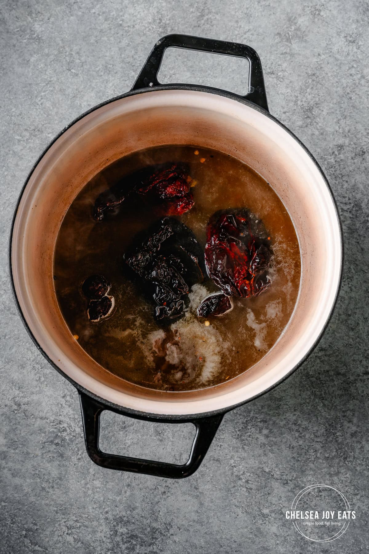 Dried chiles and broth simmering in a Dutch oven.
