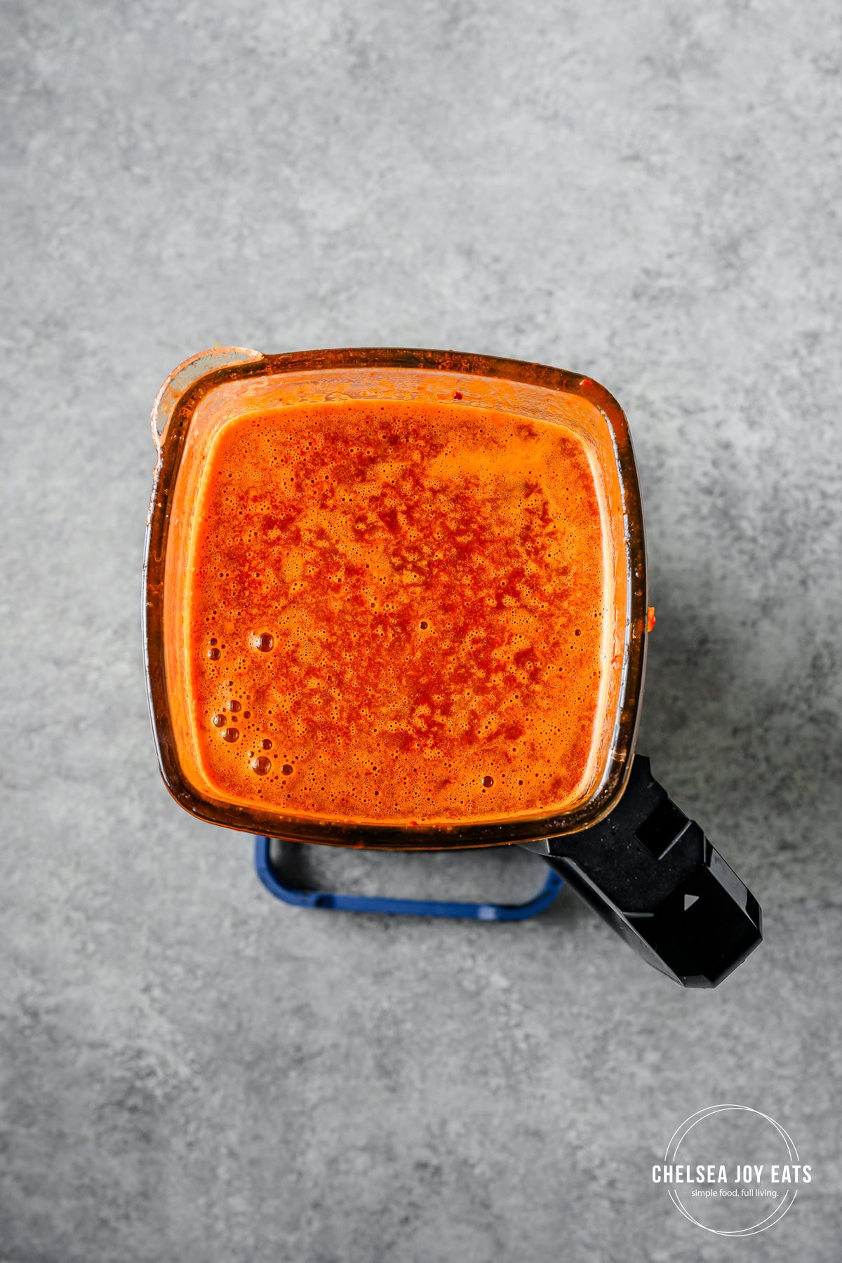 Blended barbacoa sauce made from broth, spices, and dried chiles in a blender.