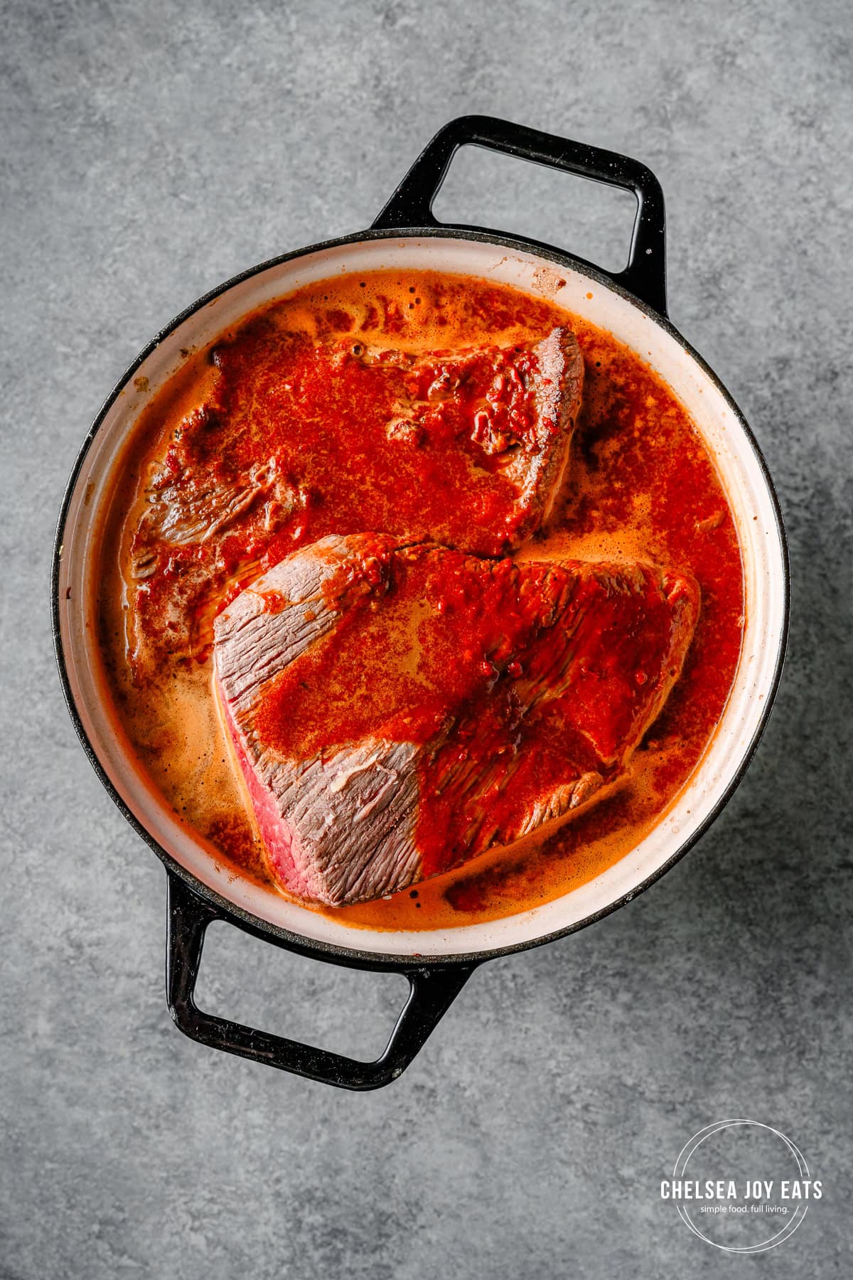 Barbacoa sauce and brisket in a Dutch oven, ready for the oven.
