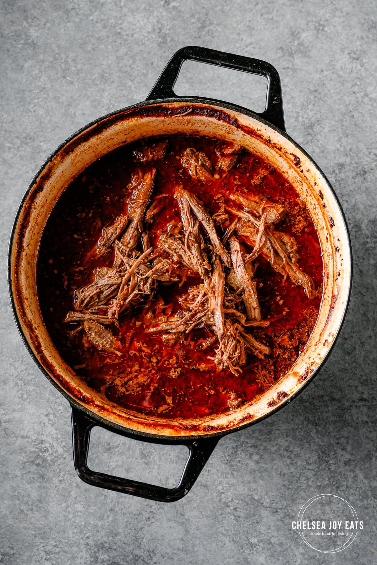 Finished barbacoa beef brisket in a Dutch oven with barbacoa sauce.