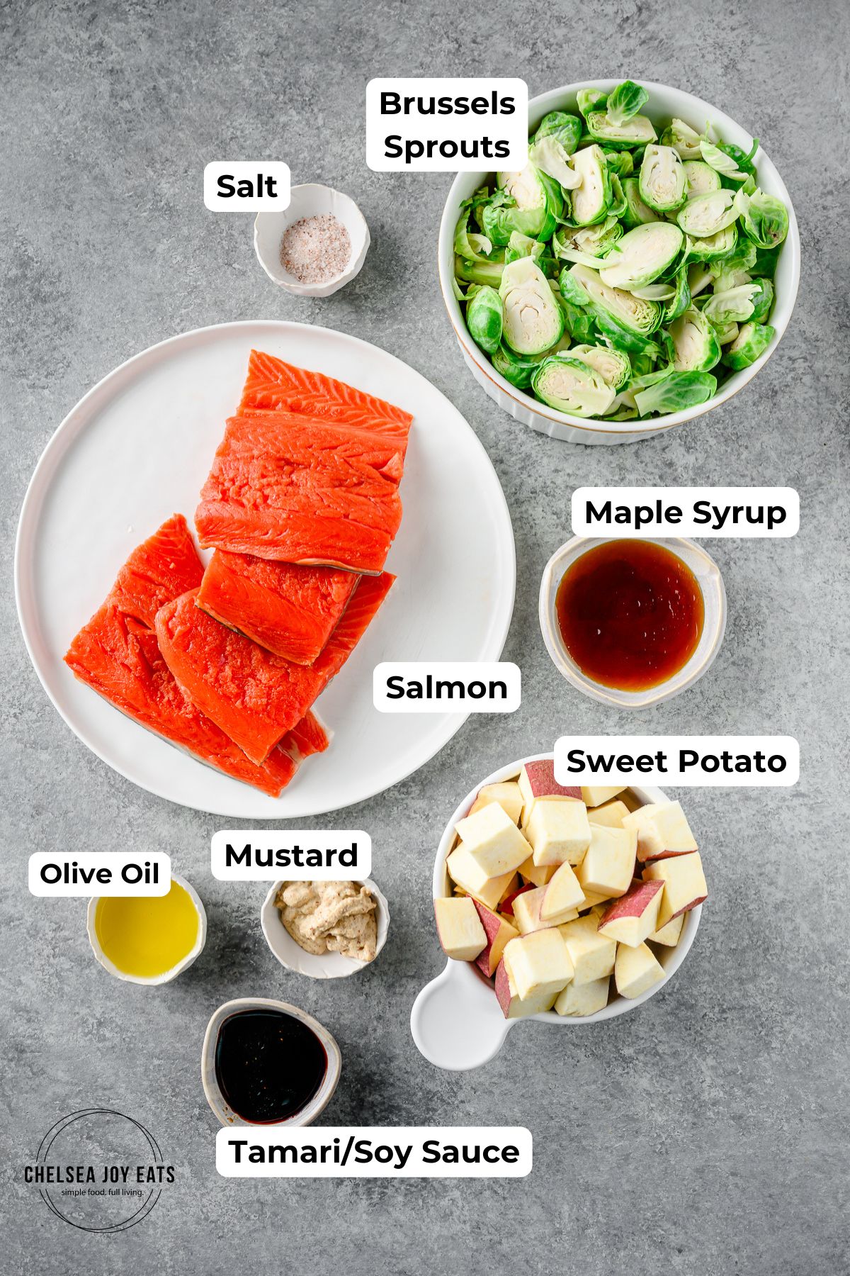 Ingredients for sheet pan maple mustard salmon with brussels sprouts and sweet potatoes with each ingredient in individual bowls.