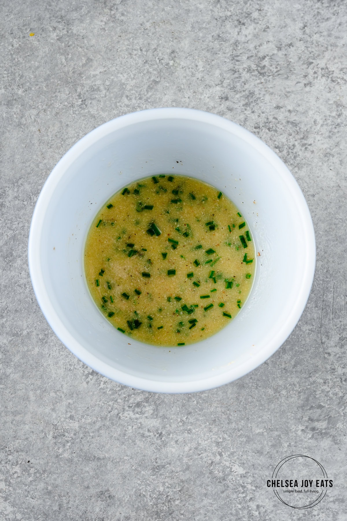 Prepared mustard chive vinaigrette in a small ceramic bowl.